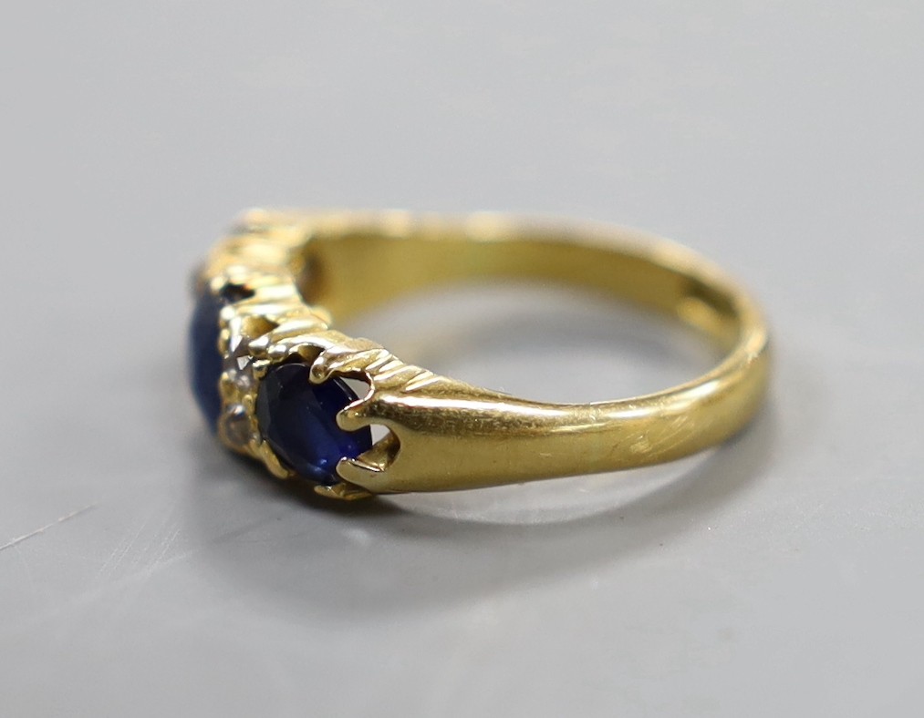 An 18ct, three stone sapphire and four stone diamond chip set half hoop ring, size L, gross weight 4 grams.